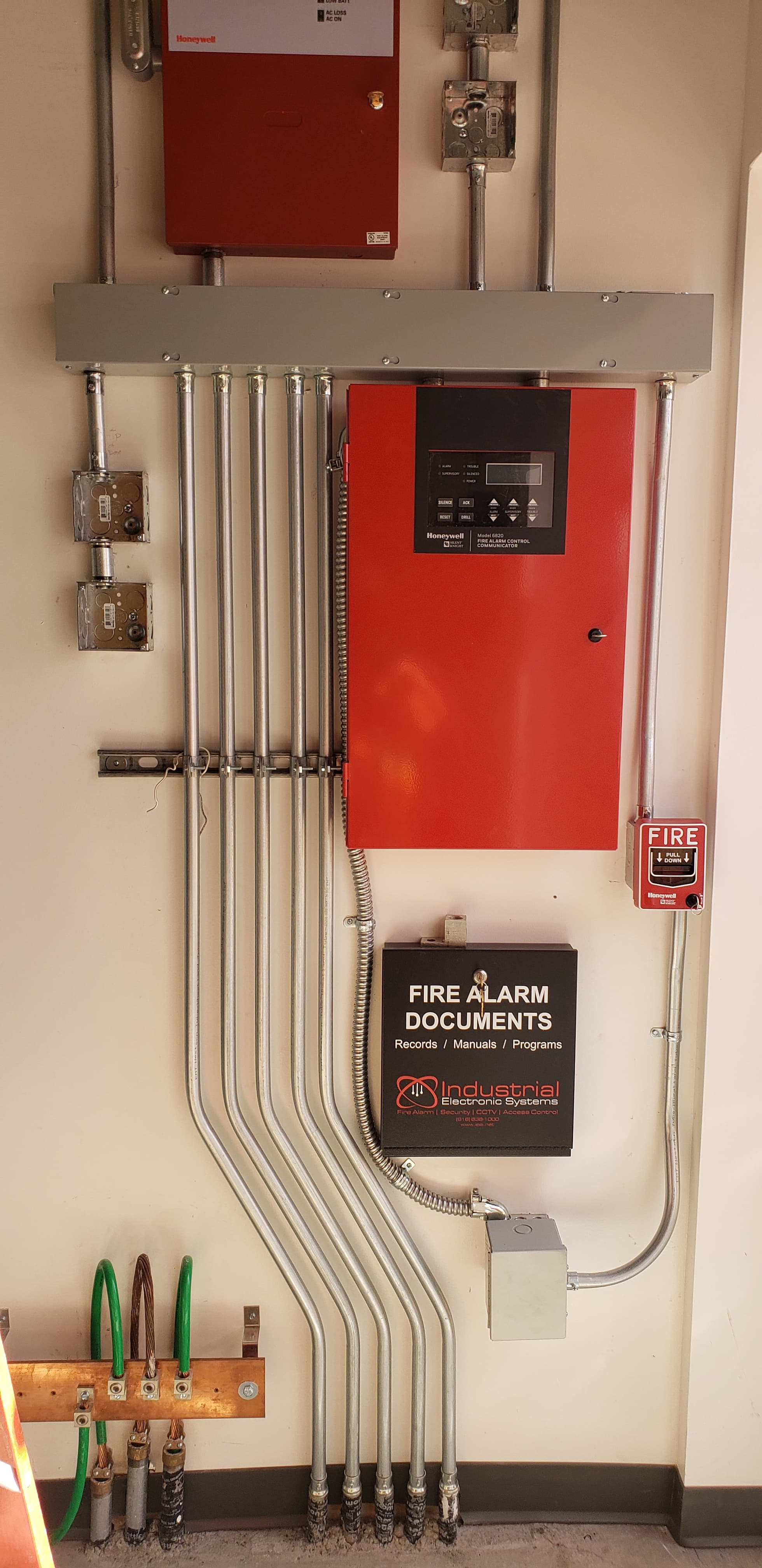 Commercial fire alarm control panel with conduit and a manual pull station