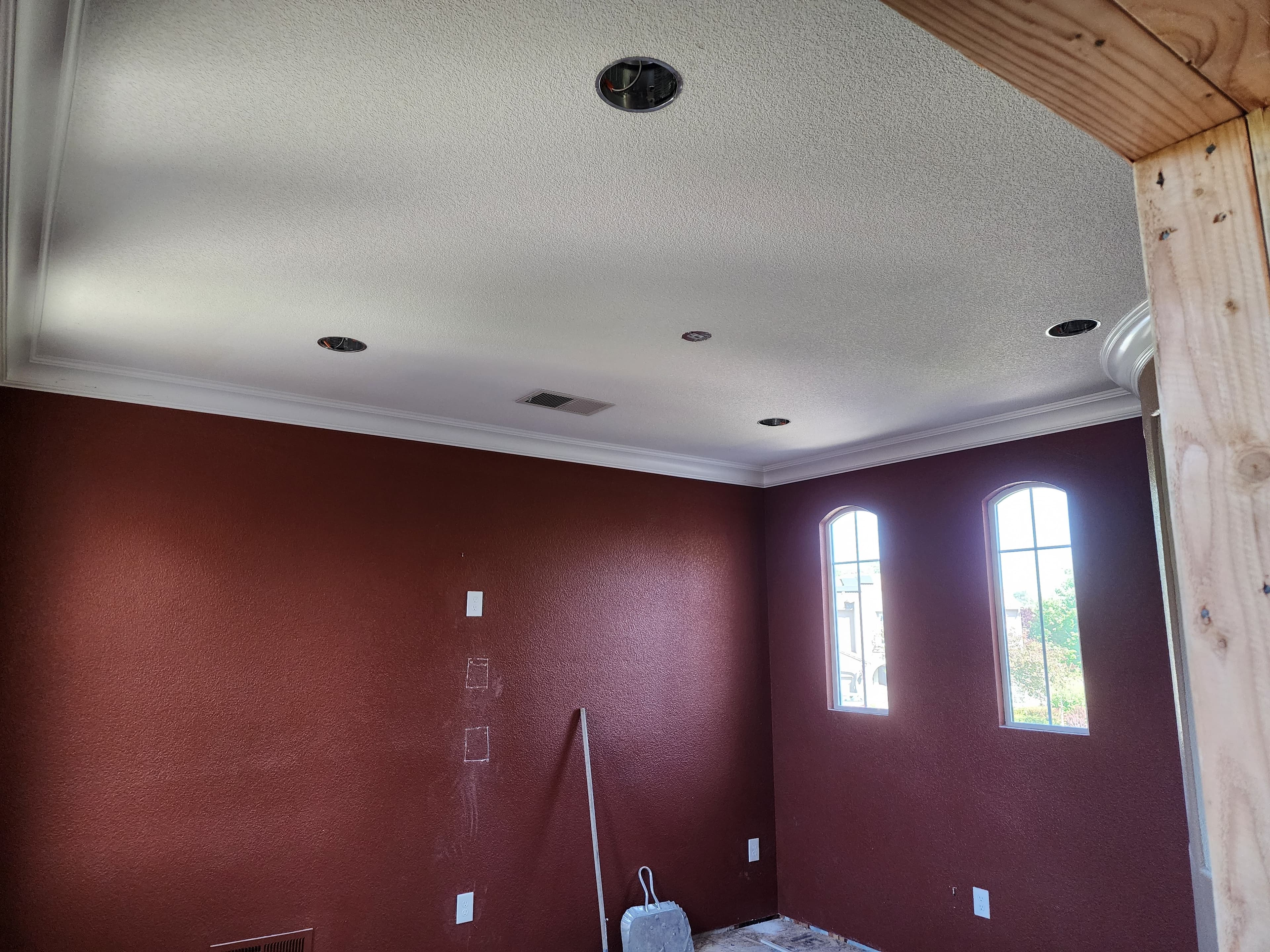 Recessed lighting installed in a room with arched windows and crown molding